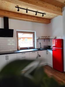 a kitchen with a red refrigerator and a window at MaGórka in Krempna