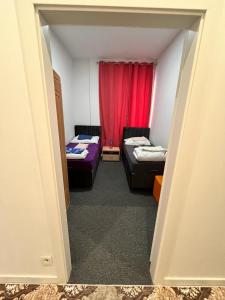 維也納的住宿－Hostel Wieden，一间设有两张床和红色窗帘的房间