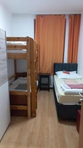 Hostel Wieden في فيينا: سريرين بطابقين في غرفة مع أرضيات خشبية