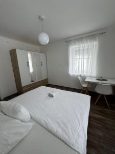 a bedroom with a large white bed and a table at Apartment Vlora-Naturblick in Villach