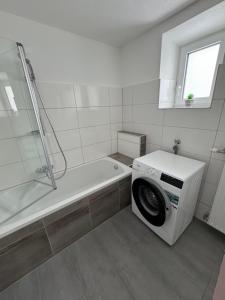 uma máquina de lavar roupa na casa de banho com um chuveiro em Apartment Vlora-Naturblick em Villach