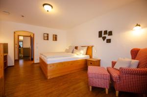 um quarto com uma cama e duas cadeiras em s`Wirtshaus Hotel & Restaurant em Oberammergau