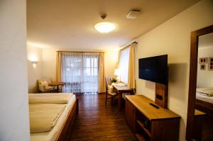 een hotelkamer met een slaapkamer met een bed en een bureau bij s`Wirtshaus Hotel & Restaurant in Oberammergau