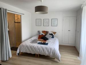 a white bedroom with a bed with pillows on it at Chambre spacieuse lit King Size in Niort