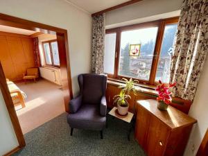 Una sala de estar con una silla y una ventana. en Ferienhaus Heimatplatzle, en Oetz