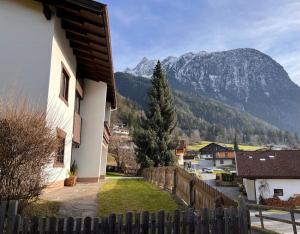 a house with a fence and mountains in the background at Ferienhaus Heimatplatzle in Oetz