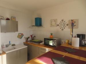 a kitchen with a counter top with a microwave at Gruissan Village APPT Duplex 51m2 in Gruissan +15 photos