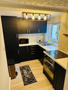 a kitchen with black cabinets and a sink at Newly refurbished - Near seafront - Retro games machine - Central Brighton - 1 bedroom apartment in Brighton & Hove