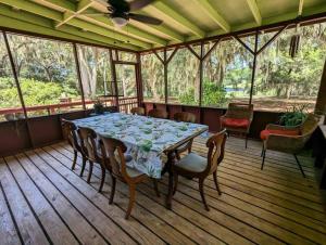 a dining room with a table and chairs on a porch at Peaceful Family Lake House in Hawthorne