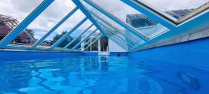 una piscina cubierta con techo de cristal y agua en Dachgeschosswohnung mit Pool en Nordleda