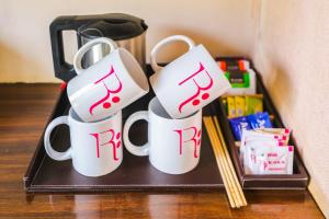 a tray with three coffee mugs with music on them at Regenta Resort Exotica Dharamshala on Hilltop in Dharamshala