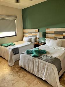 Duas camas num quarto com paredes verdes em Apt -Spacious-Modern-Luxury-Comfort-Quiet Area em Tulum