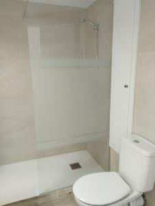 a white bathroom with a toilet and a shower at Casa Blanca in Oliva