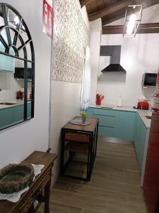 cocina con armarios azules y mesa de madera en El Mirador de la Azucena en Guadalajara