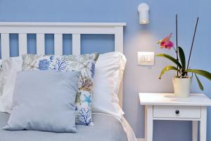 een blauwe slaapkamer met een bed met een kussen en een plant bij PR APARTMENT - FIUMICINO ROME AIRPORT 9 Min - in Fiumicino