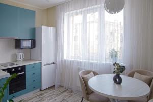 una pequeña cocina con mesa y ventana en Аппартаменты Металлист посуточно VIP en Járkov