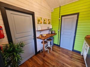 a room with green and white walls and a table at The Malvern Hills Courtyard Cabins. (Barbara Cabin) in Great Malvern
