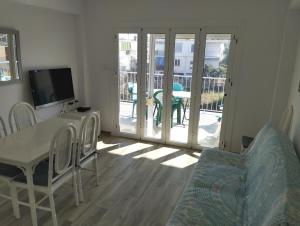 a living room with a table and chairs and a television at Casa Blanca in Oliva