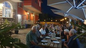 um grupo de pessoas sentadas numa mesa num restaurante em Hotel Miramonti em Dro