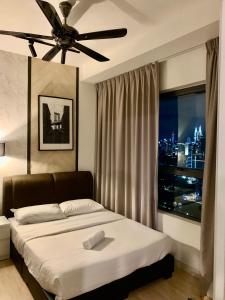 een slaapkamer met een bed en een plafondventilator bij FHS Homestay @ Arte Plus Jalan Ampang T3-33A-07 in Kuala Lumpur