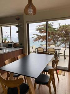 una mesa y sillas en una cocina con vistas al océano en Depto. Maitencillo 3 dormitorios, 2 estacionamientos, gran terraza frente a la playa, en Valparaíso