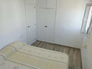オリーバにあるCasa Blancaの小さな部屋で、角にベッドが1台あります。
