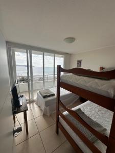a bedroom with bunk beds and a view of the ocean at Mar Serena vista al Mar in La Serena