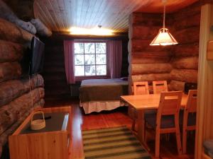 a room with a table and a bed and a dining room at Kelo Seasons Autumn in Luosto