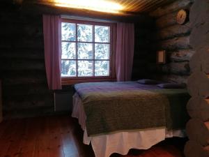 a bedroom with a bed in front of a window at Kelo Seasons Autumn in Luosto