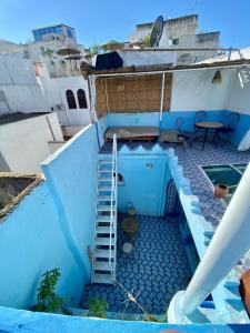 a blue building with a staircase and a table at Dar Coeur De Tanger - Riad Privé avec terrasse in Tangier