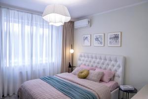 ein Schlafzimmer mit einem großen Bett mit rosa und blauer Bettwäsche in der Unterkunft Апартаменты Металлист посуточно ЛЮКС in Kharkov