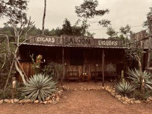 a wooden building with a sign that reads calazar saloon liquiuses at Vu Glamping in Hue