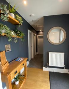 a room with a wooden table and a mirror at Bungalow33 Benllech in Benllech