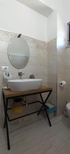 ein Badezimmer mit einem weißen Waschbecken und einem Spiegel in der Unterkunft Natura Affittacamere in Campobasso