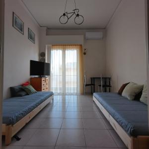 two beds in a living room with a tv at Loutraki-SPA-Apartment in Loutraki