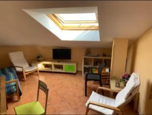 een woonkamer met een dakraam en een kamer met stoelen bij Casa Ferro Portosín in Portosin