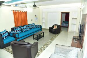 a living room with blue couches and a tv at Akash Avenue Soniya Service Apartment in Tirunelveli