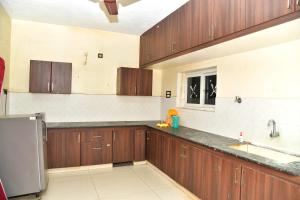 a kitchen with wooden cabinets and a stainless steel refrigerator at Akash Avenue Soniya Service Apartment in Tirunelveli