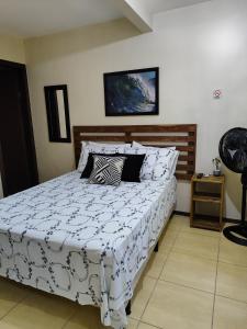 a bedroom with a bed with a white comforter at Nalua Guest House in Guarda do Embaú