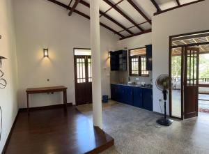 希卡杜瓦的住宿－Serenique Heaven，一间厨房,内设蓝色橱柜和风扇