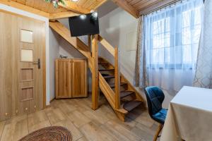a room with a staircase with a tv and a door at Dom Krawca - pod Chojnikiem in Jelenia Góra
