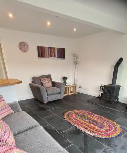 - un salon avec un canapé et un poêle à bois dans l'établissement Ednyfed Apartment, à Nefyn