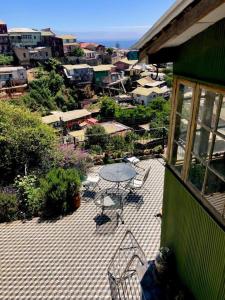 a patio with a table and chairs and a city at Casa Verde in Valparaíso
