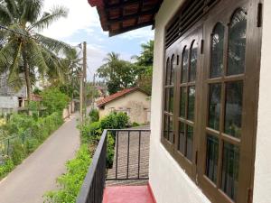un balcón de una casa con vistas a la calle en Velvette Home Hikkaduwa, en Hikkaduwa