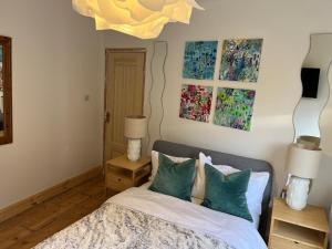 a bedroom with a bed and two lamps and paintings at Double Room at Minster Cottage in Kings Lynn