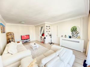 Konak的住宿－Impressive flat in the heart of Alsancak，客厅配有2张白色沙发和电视