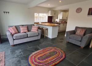 a living room with two couches and a kitchen at Ednyfed Apartment in Nefyn