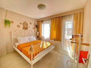 Konak的住宿－Impressive flat in the heart of Alsancak，一间卧室配有带橙色床单的床和窗户。