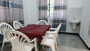 a dining room with a table and chairs and a sink at Amour Kendwa Beach House in Kendwa