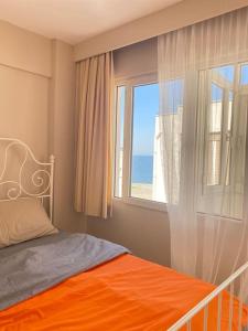 - une chambre avec un lit orange et une fenêtre dans l'établissement Impressive flat in the heart of Alsancak, à Konak